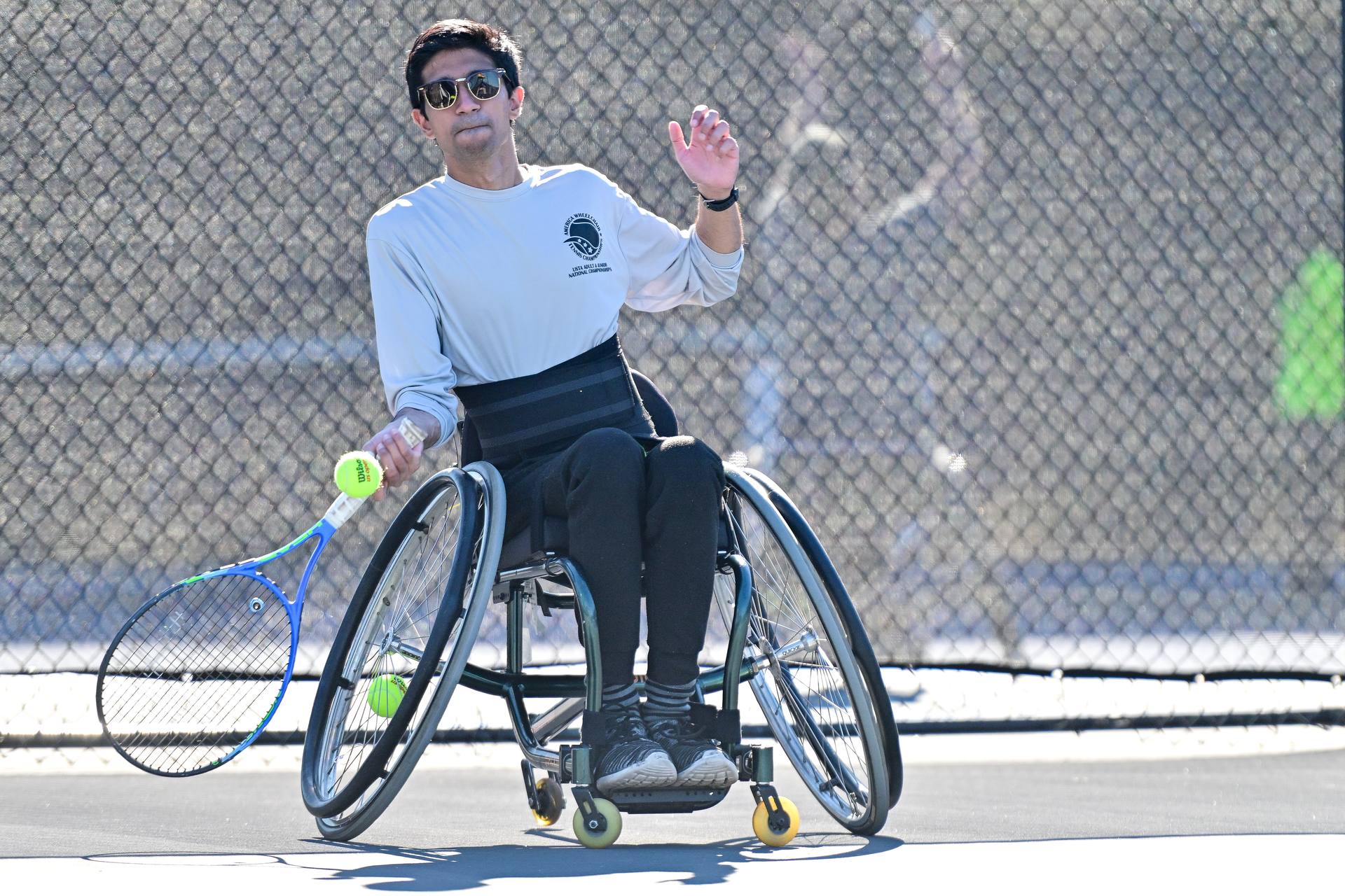 Push for Gold's founder playing wheelchair tennis on a hard court.